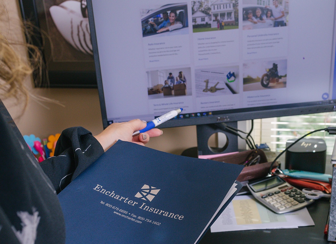 Encharter Express - Close-up of a Person Holding a Folder and Looking at a Monitor